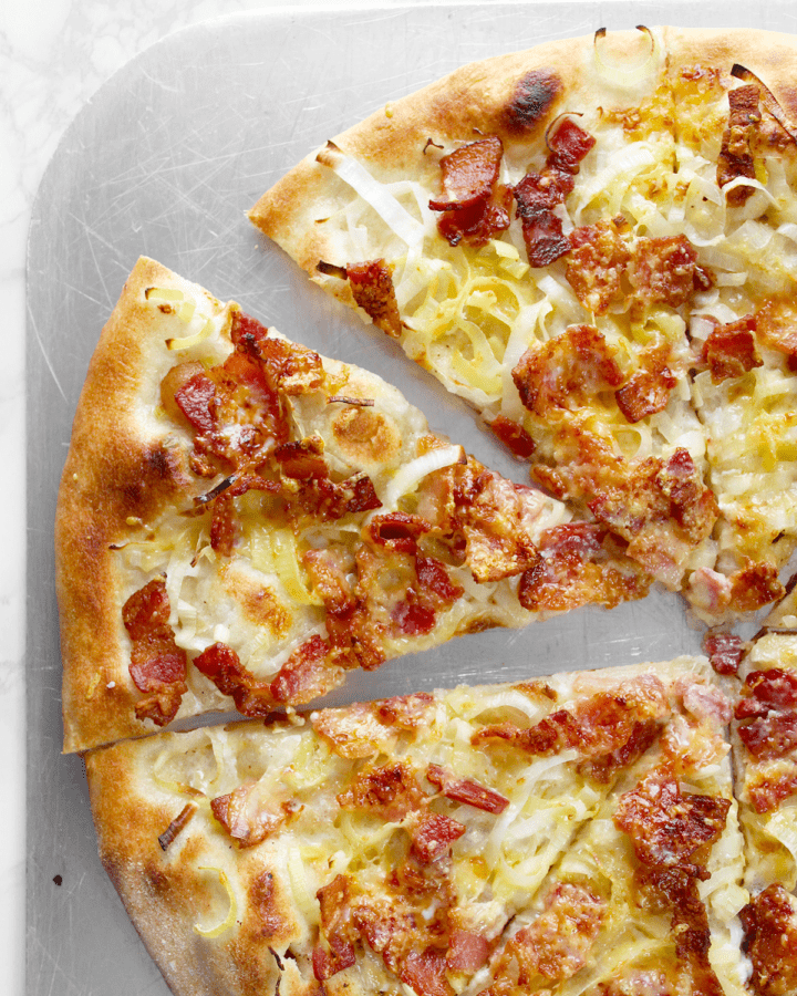white pizza with bacon sliced on pizza peel