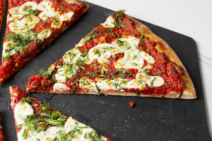 beet pesto pizza slice, close up