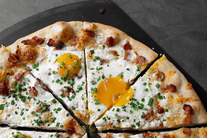 Bacon Egg and Cheese Pizza, sliced on peel