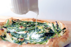 pouring cream on simple white pizza after baking
