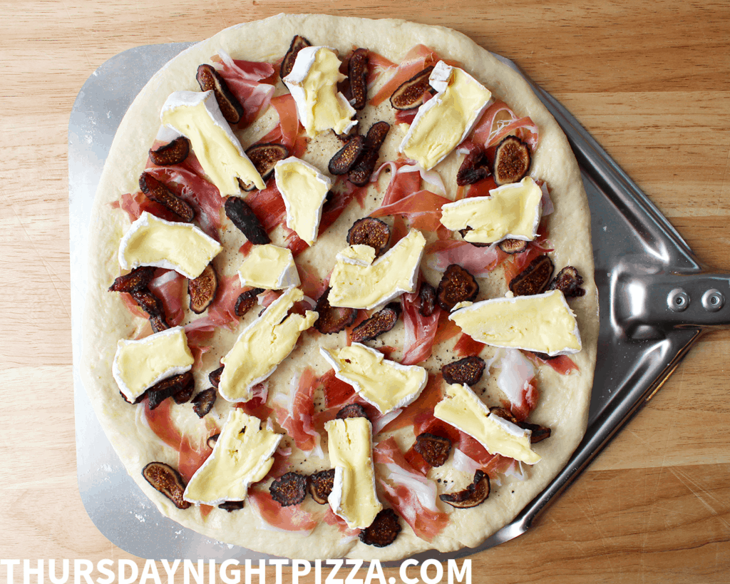 topping the pizza with brie