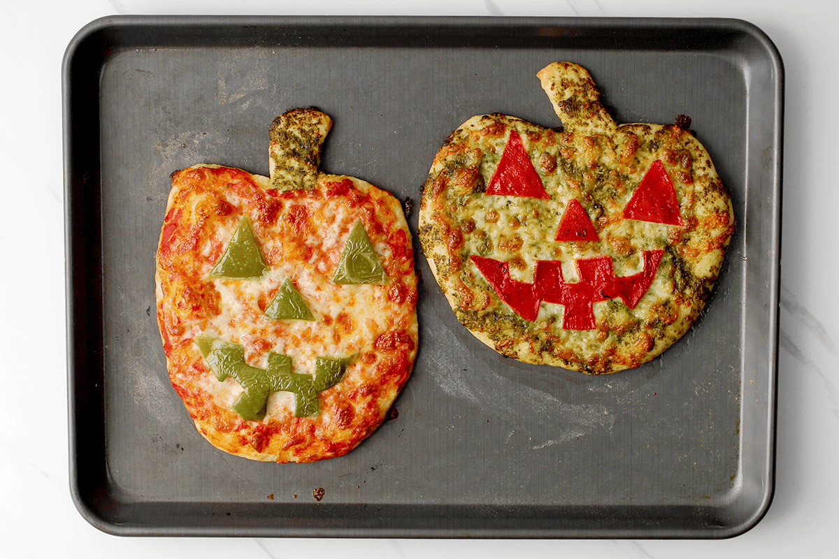 jack-o-lantern pizzas on baking sheet