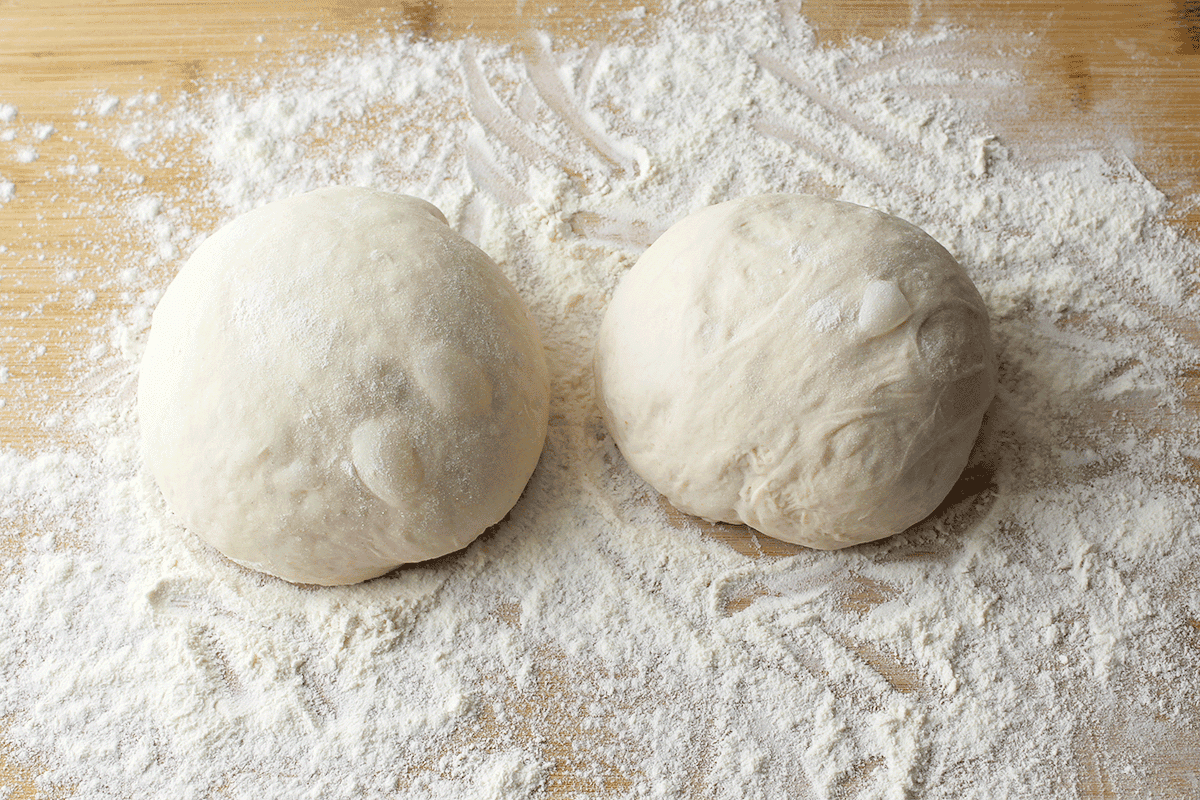 two pizza dough balls ready for stretching