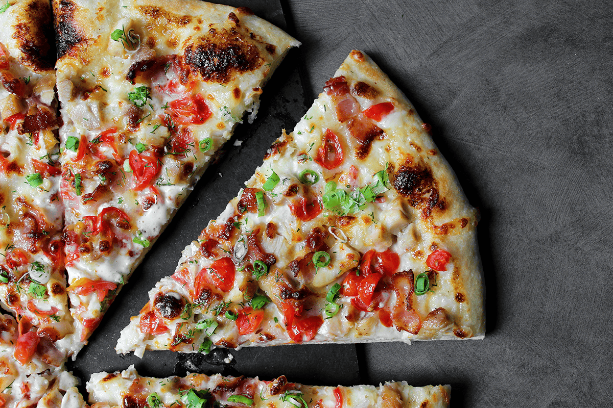 chicken bacon ranch pizza slice with tomatoes